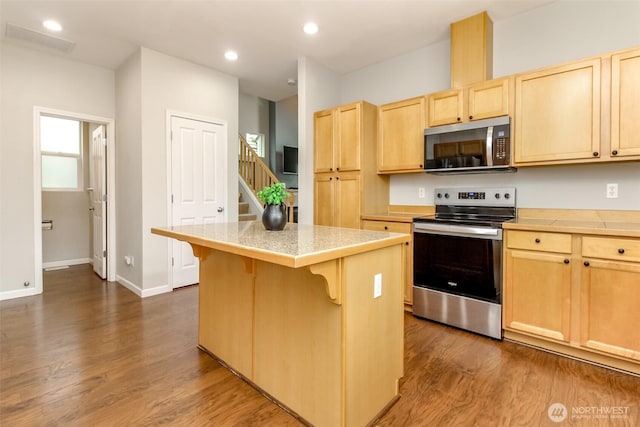 6409 Francis Ave SE, Auburn, WA 98092 - kitchen with stainless steel appliances, light brown cabinets, a kitchen breakfast bar, a center island, and light countertops