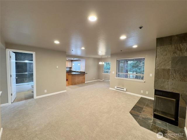 1626 Grant Ave S Unit E202, Renton, WA 98055 - unfurnished living room with a baseboard radiator, recessed lighting, a tile fireplace, and carpet floors