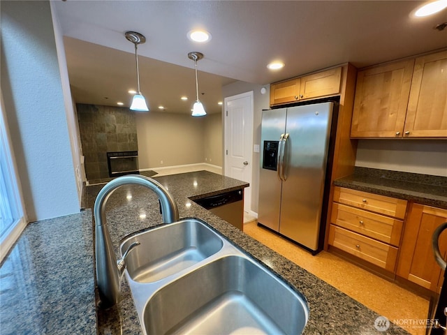 1626 Grant Ave S Unit E202, Renton, WA 98055 - kitchen featuring appliances with stainless steel finishes, dark stone counters, recessed lighting, hanging light fixtures, and a tiled fireplace