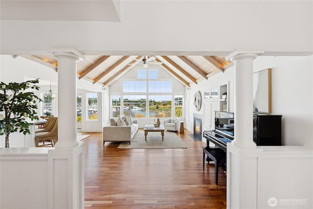 882 Shoshone Dr, La Conner, WA 98257 - living area featuring decorative columns, beamed ceiling, wood finished floors, high vaulted ceiling, and a ceiling fan