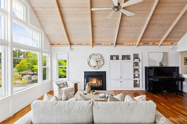 882 Shoshone Dr, La Conner, WA 98257 - living room with a wood ceiling with exposed beams, a glass covered fireplace, wood finished floors, a ceiling fan, and high vaulted ceiling