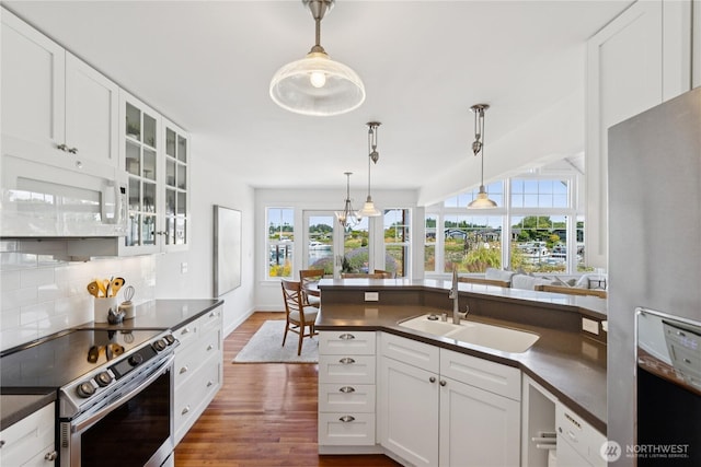 882 Shoshone Dr, La Conner, WA 98257 - kitchen with appliances with stainless steel finishes, dark countertops, dark wood-style flooring, tasteful backsplash, and white cabinetry