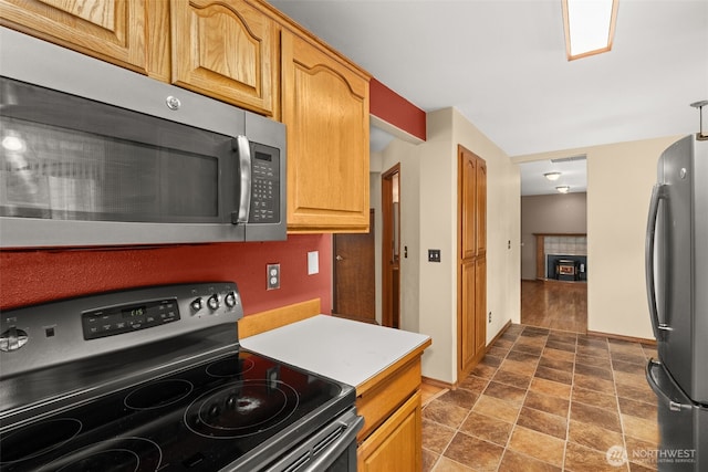 105 Clearview Cir, Chehalis, WA 98532 - kitchen featuring stainless steel appliances, a tiled fireplace, light countertops, and stone finish flooring