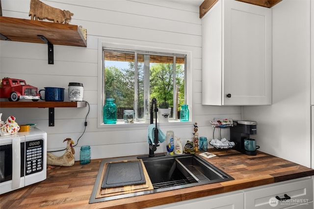 174 Skinner Rd, Chehalis, WA 98532 - kitchen with wooden counters, white microwave, white cabinets, open shelves, and wooden walls
