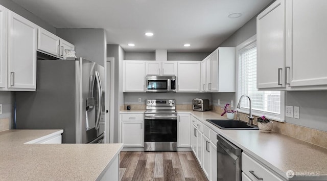 16223 Birkland St SE, Yelm, WA 98597 - kitchen with stainless steel appliances, white cabinets, wood finished floors, and recessed lighting
