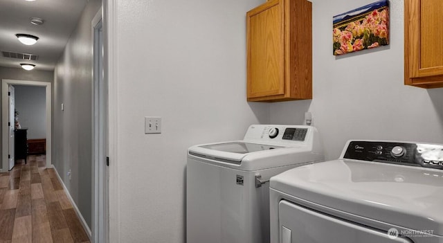 16223 Birkland St SE, Yelm, WA 98597 - washroom featuring cabinet space, wood finished floors, and washing machine and clothes dryer