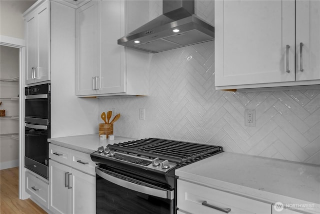 20625 153rd St E, Bonney Lake, WA 98391 - kitchen featuring stainless steel gas range oven, wall chimney range hood, decorative backsplash, and white cabinetry