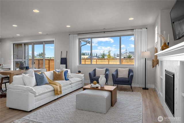 20625 153rd St E, Bonney Lake, WA 98391 - living room featuring light wood-type flooring, recessed lighting, and a fireplace