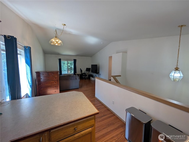 15730 91st Way SE, Yelm, WA 98597 - kitchen featuring vaulted ceiling, wood finished floors, hanging light fixtures, a desk, and light countertops