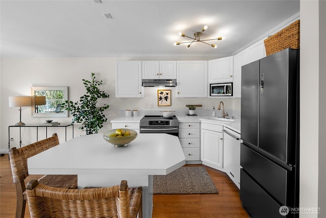 2501 Canterbury Ln E Unit 221, Seattle, WA 98112 - kitchen featuring stainless steel appliances, under cabinet range hood, dark wood-style floors, white cabinetry, and ornamental molding