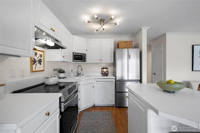 2501 Canterbury Ln E Unit 221, Seattle, WA 98112 - kitchen with stainless steel appliances, under cabinet range hood, white cabinetry, and ornamental molding
