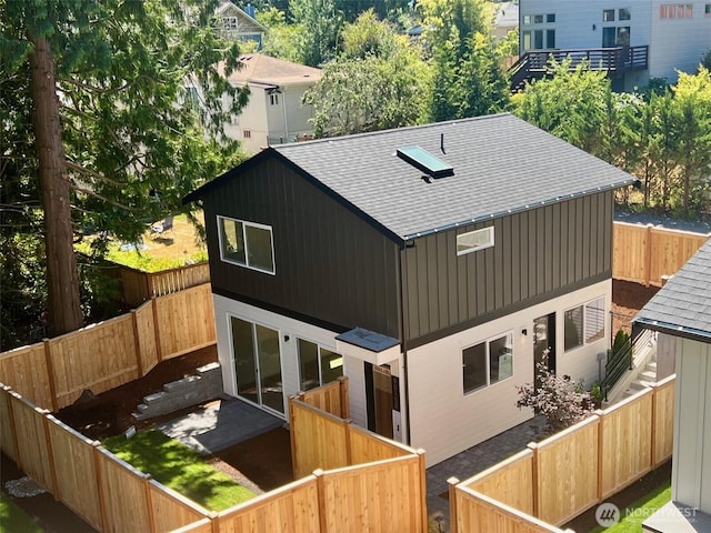 9015 Dibble Ave NW Unit B, Seattle, WA 98117 - back of property featuring a shingled roof and a fenced backyard