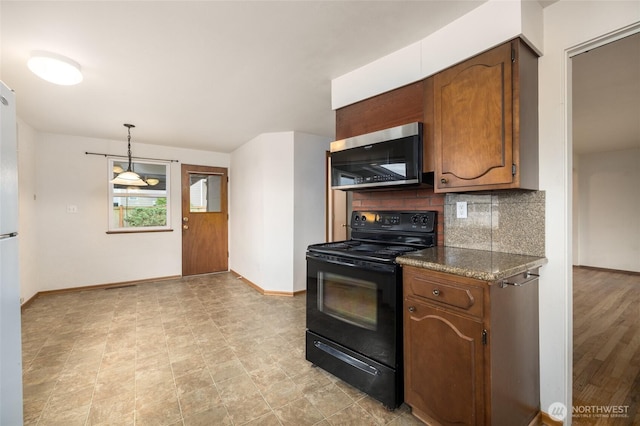1411 38th St, Anacortes, WA 98221 - kitchen with black electric range, stainless steel microwave, decorative backsplash, dark countertops, and pendant lighting