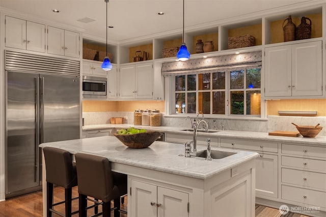1617 Federal Ave E, Seattle, WA 98102 - kitchen with built in appliances, white cabinetry, and a center island with sink