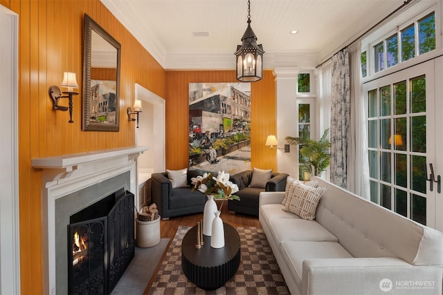 1617 Federal Ave E, Seattle, WA 98102 - living room featuring a warm lit fireplace, a chandelier, ornamental molding, wood finished floors, and wooden walls