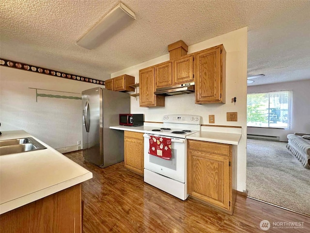 798 Division Ave, Morton, WA 98356 - kitchen with electric stove, under cabinet range hood, stainless steel fridge, a textured ceiling, and a baseboard radiator
