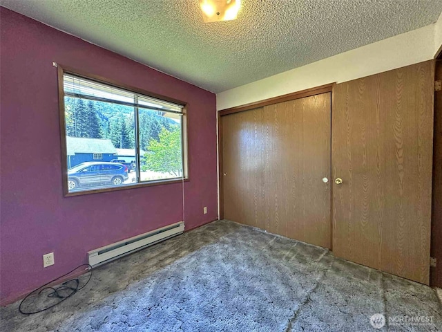 798 Division Ave, Morton, WA 98356 - unfurnished bedroom featuring a baseboard heating unit, carpet, a textured ceiling, and a closet