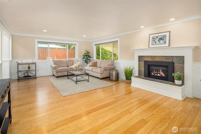 108 151st Pl SE, Lynnwood, WA 98087 - living area featuring wood finished floors, a tiled fireplace, a wainscoted wall, ornamental molding, and a decorative wall