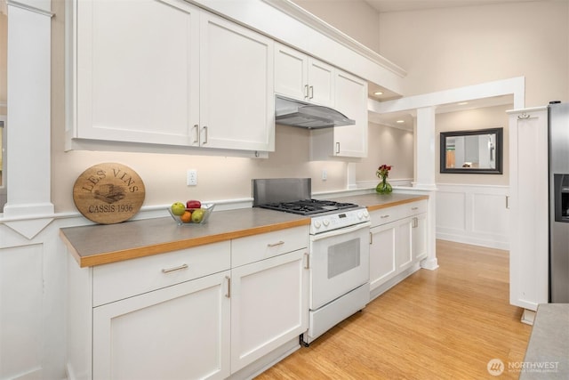 108 151st Pl SE, Lynnwood, WA 98087 - kitchen with white gas range, under cabinet range hood, white cabinetry, a decorative wall, and wainscoting