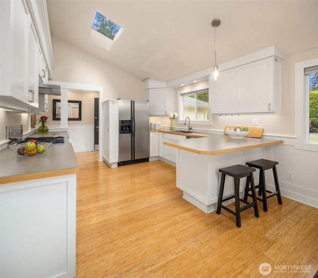 108 151st Pl SE, Lynnwood, WA 98087 - kitchen featuring stainless steel appliances, a peninsula, a skylight, light wood finished floors, and lofted ceiling