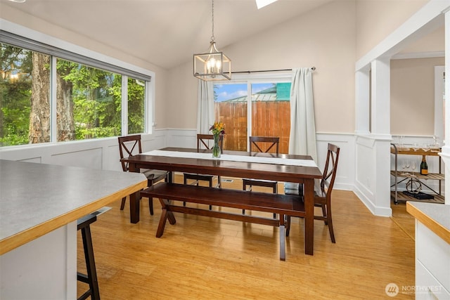 108 151st Pl SE, Lynnwood, WA 98087 - dining space featuring a chandelier, vaulted ceiling, light wood-style floors, a wainscoted wall, and a decorative wall