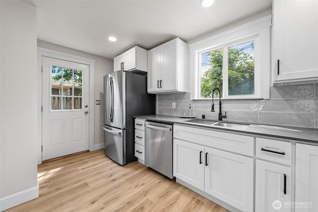6416 S Huson St, Tacoma, WA 98409 - kitchen featuring stainless steel appliances, decorative backsplash, white cabinetry, recessed lighting, and light wood finished floors