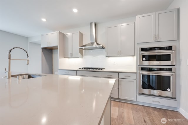 21725 SE 292 Nd Pl, Black Diamond, WA 98010 - kitchen featuring wall chimney exhaust hood, stainless steel appliances, light wood-style floors, tasteful backsplash, and light stone counters