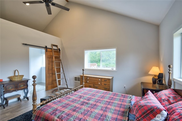 53 E Elma Mccleary Rd, Elma, WA 98514 - bedroom featuring wood finished floors, high vaulted ceiling, a barn door, and a ceiling fan