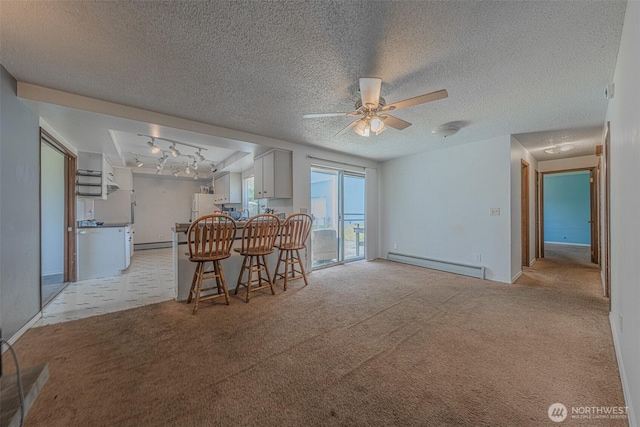 5735 NE 8th St, Renton, WA 98059 - dining area featuring a baseboard radiator, a ceiling fan, light carpet, rail lighting, and a textured ceiling