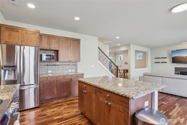 13218 106th Pl NE, Kirkland, WA 98034 - kitchen featuring stainless steel appliances, dark wood-style floors, open floor plan, tasteful backsplash, and light stone counters