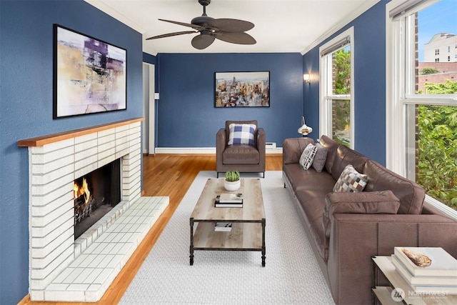 404 E Harrison St Unit 301, Seattle, WA 98102 - living area featuring ornamental molding, wood finished floors, a ceiling fan, and a brick fireplace