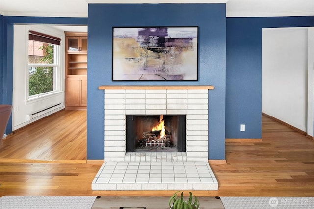 404 E Harrison St Unit 301, Seattle, WA 98102 - detailed view of a baseboard radiator, wood finished floors, crown molding, and a fireplace