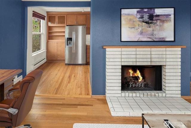 404 E Harrison St Unit 301, Seattle, WA 98102 - living area with light wood-type flooring, a baseboard radiator, and a fireplace