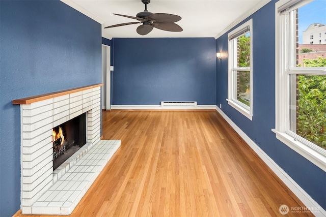 404 E Harrison St Unit 301, Seattle, WA 98102 - unfurnished living room with a baseboard heating unit, ornamental molding, wood finished floors, a ceiling fan, and a fireplace