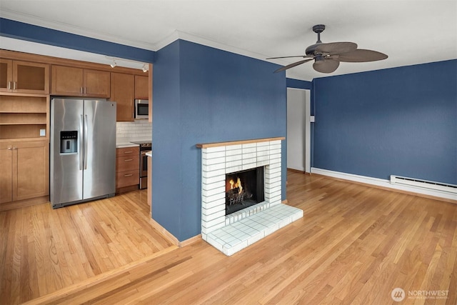 404 E Harrison St Unit 301, Seattle, WA 98102 - unfurnished living room with ceiling fan, light wood-style floors, a fireplace, a baseboard heating unit, and ornamental molding