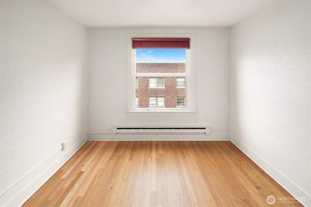 404 E Harrison St Unit 301, Seattle, WA 98102 - spare room featuring a baseboard heating unit and light wood-style floors