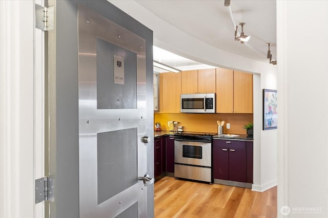 732 11th Ave E Unit 404, Seattle, WA 98102 - kitchen with appliances with stainless steel finishes, dark countertops, and light wood-type flooring