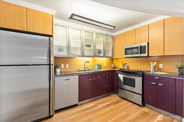 732 11th Ave E Unit 404, Seattle, WA 98102 - kitchen featuring appliances with stainless steel finishes, light wood-style flooring, dark stone countertops, and glass insert cabinets