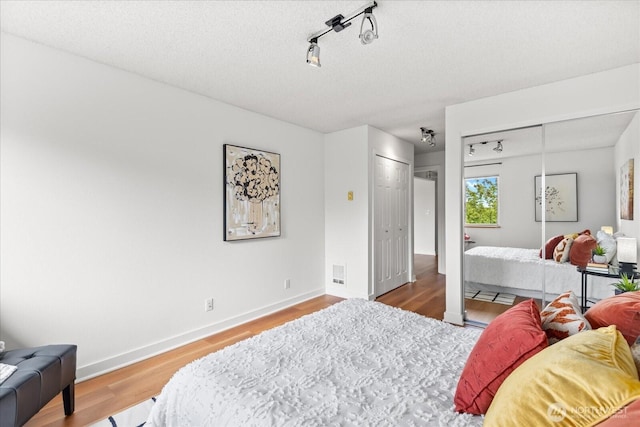 732 11th Ave E Unit 404, Seattle, WA 98102 - bedroom featuring wood finished floors, rail lighting, and a textured ceiling