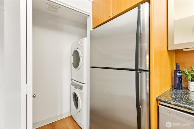 732 11th Ave E Unit 404, Seattle, WA 98102 - washroom featuring stacked washing machine and dryer and light wood-style flooring