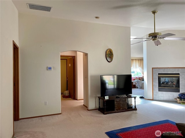 9238 Classic Dr NE, Lacey, WA 98516 - living room with light carpet, arched walkways, a ceiling fan, and a tile fireplace