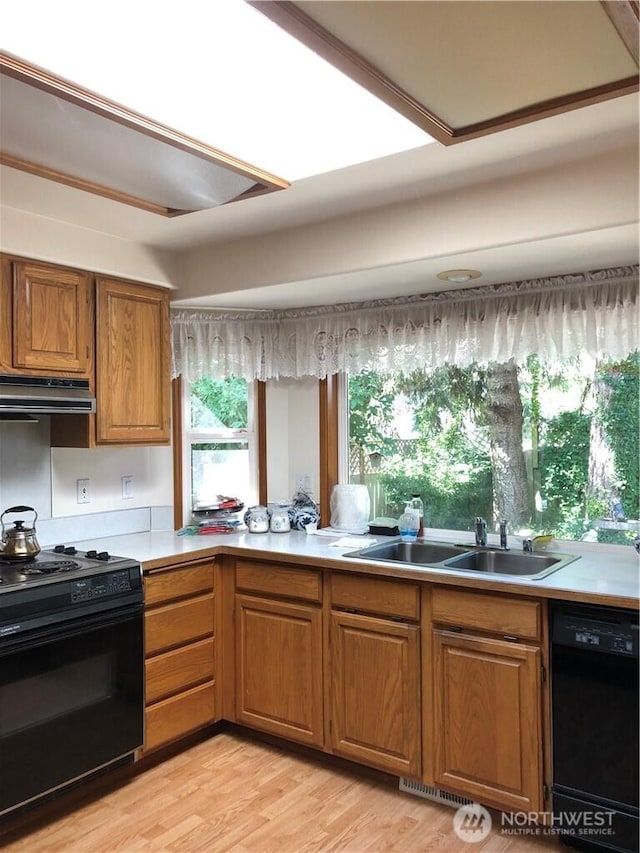 9238 Classic Dr NE, Lacey, WA 98516 - kitchen featuring black appliances, range hood, brown cabinets, light countertops, and light wood-style floors