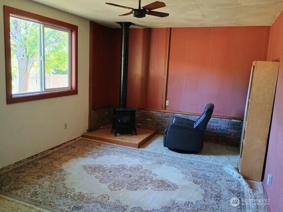 3295 Hastings Ave, Port Townsend, WA 98368 - unfurnished room with a wood stove, a ceiling fan, and carpet flooring
