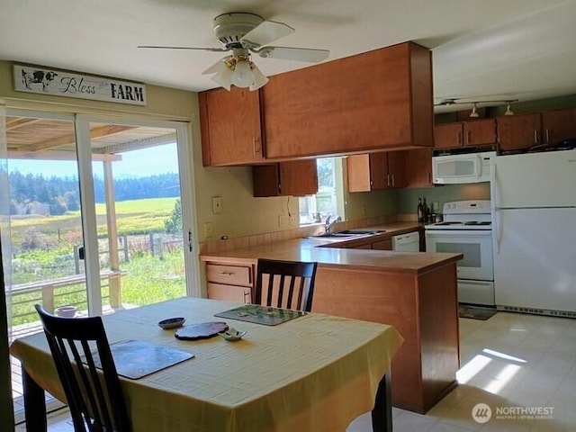 3295 Hastings Ave, Port Townsend, WA 98368 - kitchen featuring white appliances, rail lighting, ceiling fan, a peninsula, and brown cabinetry