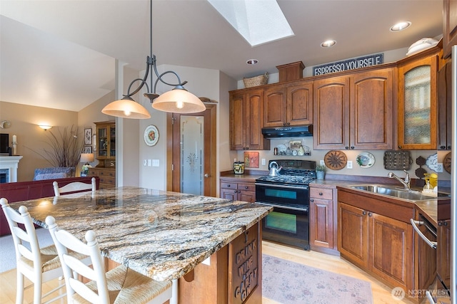 1901 W Hamilton Way, Port Angeles, WA 98363 - kitchen with range with two ovens, under cabinet range hood, a skylight, a kitchen breakfast bar, and glass insert cabinets