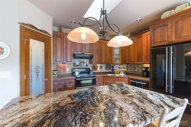 1901 W Hamilton Way, Port Angeles, WA 98363 - kitchen with black range with gas stovetop, paneled built in fridge, under cabinet range hood, dishwashing machine, and dark stone counters