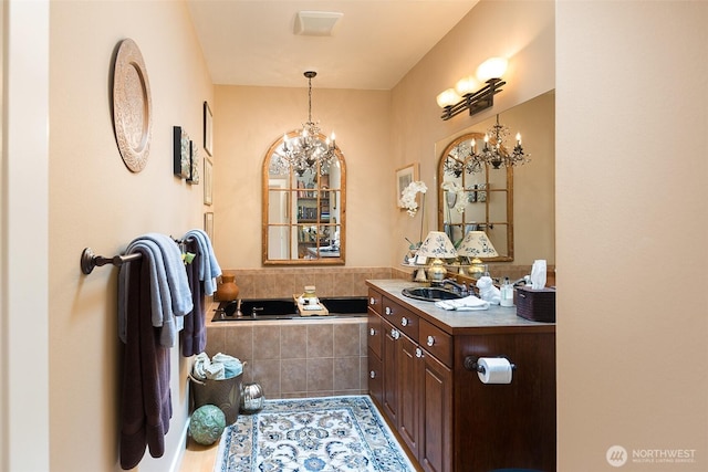 1901 W Hamilton Way, Port Angeles, WA 98363 - bathroom featuring a chandelier, vanity, and a relaxing tiled tub