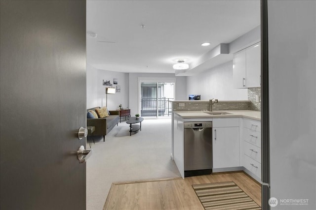 425 Vine St Unit 614, Seattle, WA 98121 - kitchen featuring stainless steel dishwasher, light wood finished floors, a peninsula, white cabinets, and light countertops