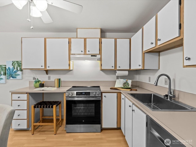 5225 50th Ave NE Unit 103, Seattle, WA 98105 - kitchen with electric range, under cabinet range hood, dishwashing machine, light wood-style floors, and light countertops