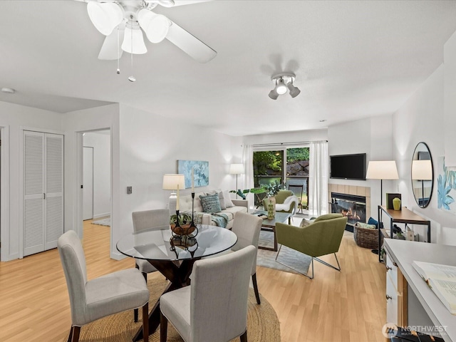 5225 50th Ave NE Unit 103, Seattle, WA 98105 - dining area with light wood-type flooring, a tiled fireplace, and ceiling fan